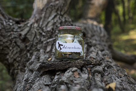 Collection of money in a glass jar for adventure.の写真素材