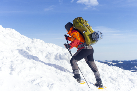 Winter hiking in the mountains on snowshoes with a backpack and tent.の写真素材