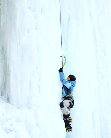 Ice climbing the North Caucasus, man climbing frozen waterfall.