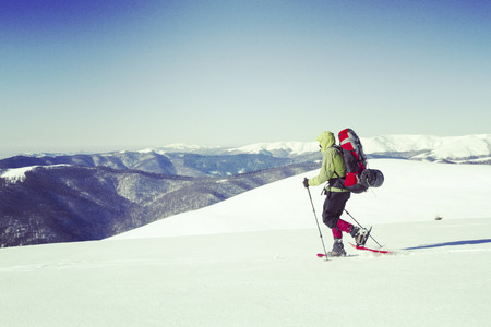Winter hiking in the mountains on snowshoes with a backpack and tent.の写真素材