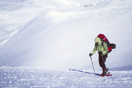 Winter hiking in the mountains on snowshoes with a backpack and tent.の写真素材