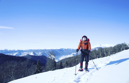 Winter hiking in the mountains on snowshoes with a backpack and tent.の写真素材