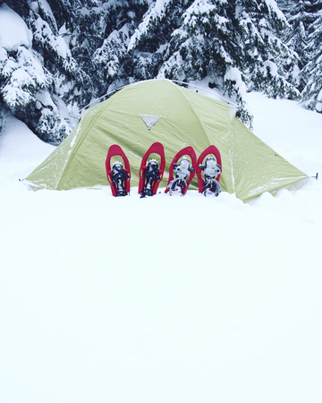 Winter hiking in the mountains on snowshoes with a backpack and tent.の写真素材