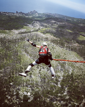 Jump off a cliff into a canyon with a rope.の写真素材