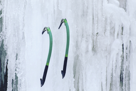 Man climbing a frozen waterfall with ice tool.の写真素材