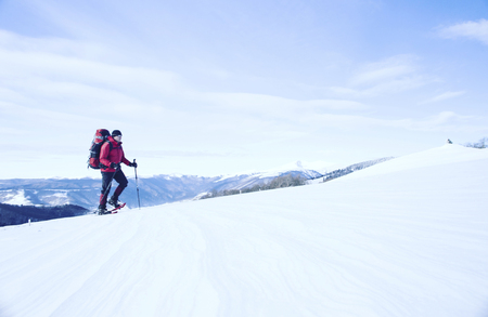 Winter hiking in the mountains on snowshoes with a backpack and tent.の写真素材