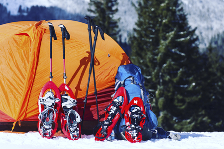 Winter hiking in the mountains on snowshoes with a backpack and tent.の写真素材