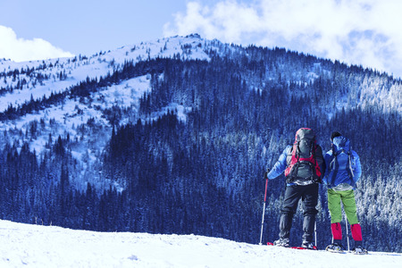 Winter hiking in the mountains on snowshoes with a backpack and tent.の写真素材