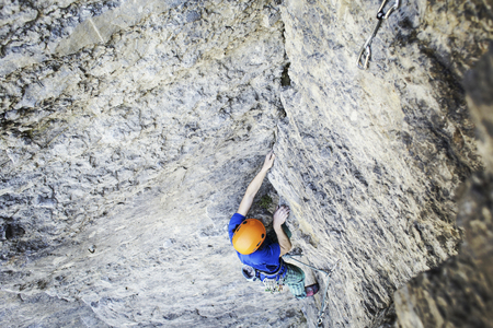 Rock climber reaching for his next hand hold, Joshua Tree National Park.の写真素材