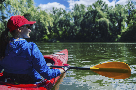 A girl rafts down the river on a kayak.の写真素材