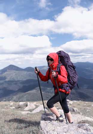 Traveler Woman hiking in mountains with backpack Travel Lifestyle concept adventure summer vacations outdoor mountaineering sport active leisure into the wildの写真素材
