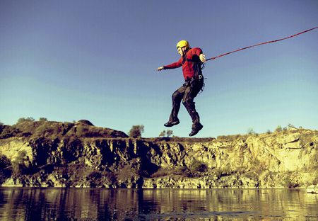 Jump off a cliff into a canyon with a rope.の写真素材