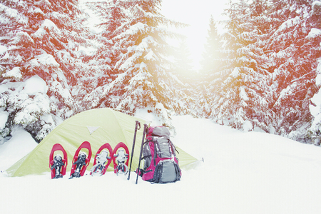 Winter trekking in the mountains. The tent stands on the mountainside against the backdrop of the mountains.の写真素材
