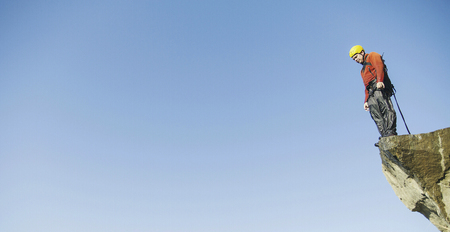 A man jumps into the abyss against the sky.の写真素材