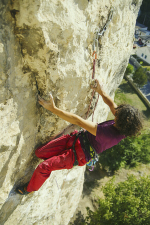 A climber climbs an ascent to a cliff.の写真素材
