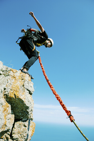 A man jumps from a cliff into the abyss.の写真素材