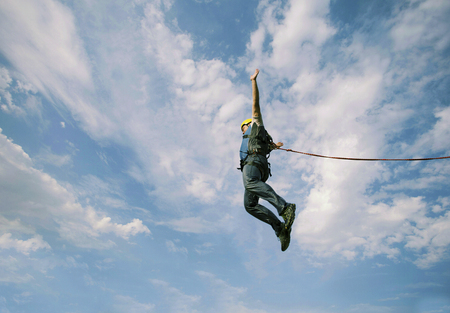 A man is jumping from a cliff to an abyss.の写真素材