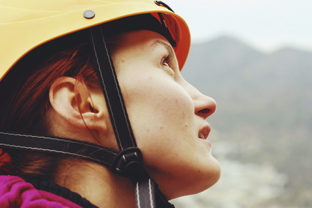 A young woman with a rope engaged in the sports of rock climbing on the rock.の写真素材