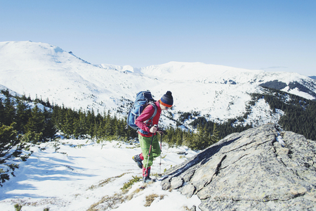 Hiker in winter mountains. Man with backpack trekking in mountains. Winter hiking.の写真素材