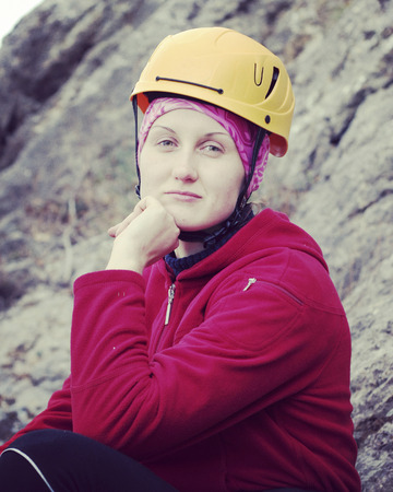 Woman rock climber. Rock climber climbs on a rocky wall. Woman makes hard move.の写真素材