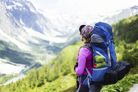 Trek around Mont Blanc. The girl is walking along the trail with a backpack.の写真素材