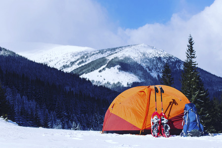 Winter hike in the mountains. Snowshoes are in the snow near the tent.の写真素材
