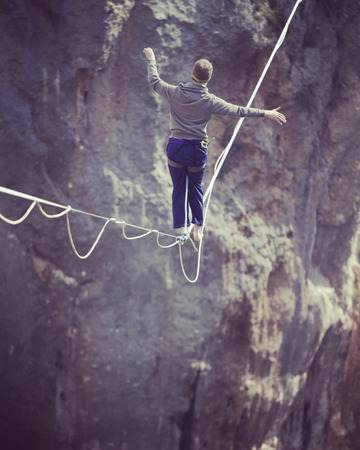 Man balancing on the rope concept of risk taking and challenge.