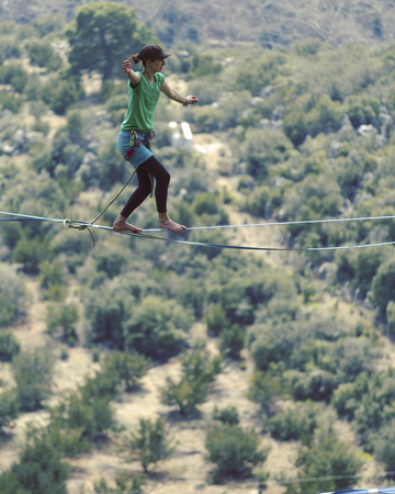 Woman balancing on the rope concept of risk taking and challenge.