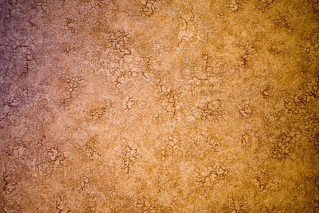 the wall in the cracks of the background is brown with black cracksの写真素材