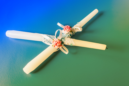 Two wedding candles lie on a blue green background. Decorated Candlesの写真素材