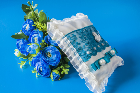 Wedding cushion and flowers on a blue backgroundの写真素材