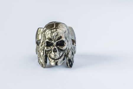 Silver skull ring on white background. The skull looks and smilesの写真素材