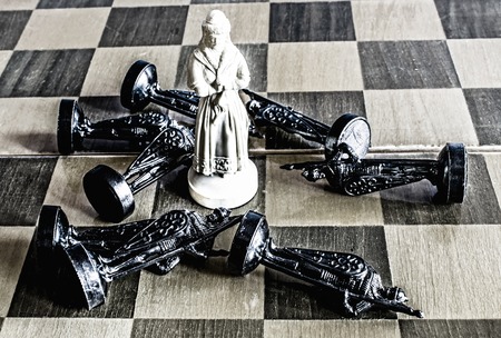 A lady on a chess black and white board. A white lady won black pawns.の写真素材