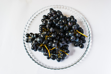 Dark grapes on a tray, on a light backgroundの写真素材