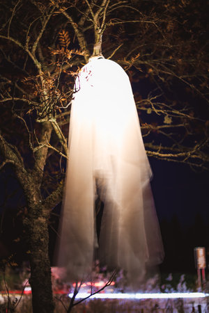 Spooky Halloween photo of a ghost figure in the dark with eerie lighting and misty atmosphere....