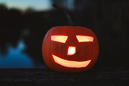 Spooky Halloween photo with carved pumpkins glowing in the dark. Festive autumn atmosphere with candle light, orange pumpkins, and seasonal decorations - perfect for holiday, Halloween, and fall themes.の写真素材