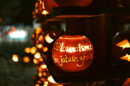 Spooky Halloween photo with carved pumpkins glowing in the dark. Festive autumn atmosphere with candle light, orange pumpkins, and seasonal decorations - perfect for holiday, Halloween, and fall themes.の写真素材
