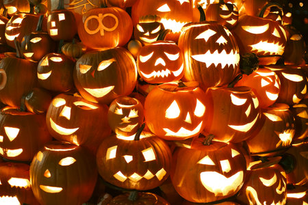 Spooky Halloween photo with carved pumpkins glowing in the dark. Festive autumn atmosphere with candle light, orange pumpkins, and seasonal decorations - perfect for holiday, Halloween, and fall themes.の写真素材