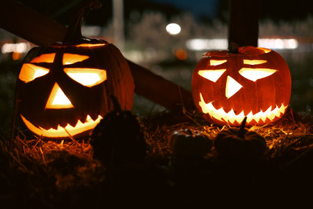 Spooky Halloween photo with carved pumpkins glowing in the dark. Festive autumn atmosphere with candle light, orange pumpkins, and seasonal decorations - perfect for holiday, Halloween, and fall themes.の写真素材