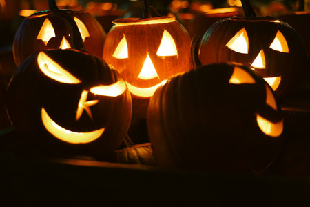 Spooky Halloween photo with carved pumpkins glowing in the dark. Festive autumn atmosphere with candle light, orange pumpkins, and seasonal decorations - perfect for holiday, Halloween, and fall themes.の写真素材