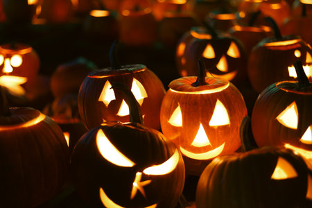 Spooky Halloween photo with carved pumpkins glowing in the dark. Festive autumn atmosphere with candle light, orange pumpkins, and seasonal decorations - perfect for holiday, Halloween, and fall themes.の写真素材