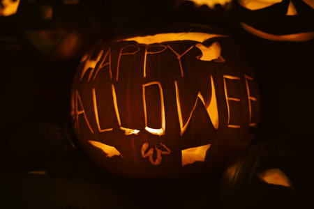 Spooky Halloween photo with carved pumpkins glowing in the dark. Festive autumn atmosphere with candle light, orange pumpkins, and seasonal decorations - perfect for holiday, Halloween, and fall themes.の写真素材