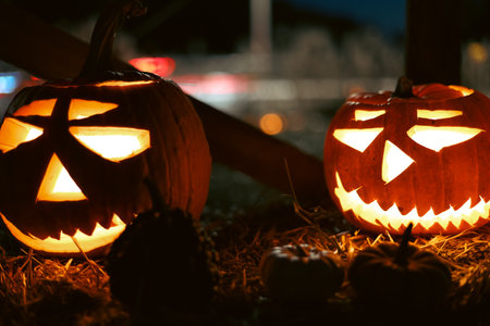 Spooky Halloween photo with carved pumpkins glowing in the dark. Festive autumn atmosphere with...