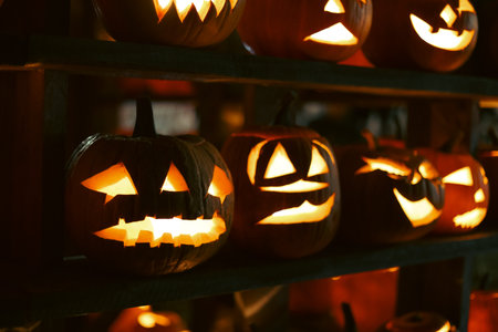 Spooky Halloween photo with carved pumpkins glowing in the dark. Festive autumn atmosphere with candle light, orange pumpkins, and seasonal decorations - perfect for holiday, Halloween, and fall themes.の写真素材