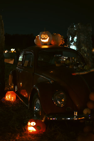 Spooky Halloween photo with carved pumpkins glowing in the dark. Festive autumn atmosphere with candle light, orange pumpkins, and seasonal decorations - perfect for holiday, Halloween, and fall themes.の写真素材