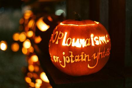 Spooky Halloween photo with carved pumpkins glowing in the dark. Festive autumn atmosphere with candle light, orange pumpkins, and seasonal decorations - perfect for holiday, Halloween, and fall themes.の写真素材