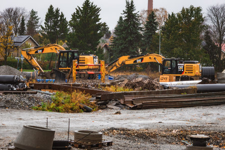 Construction site with heavy machinery, metal structures, and construction materials. Industrial...