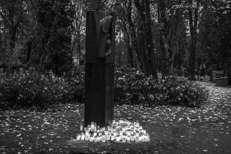Black and white photograph of cemetery crosses and glowing lanterns, soft candlelight creating a deep emotional and spiritual atmosphere. The monochrome style emphasizes contrast, symbolism and the quiet mood of remembrance.の写真素材