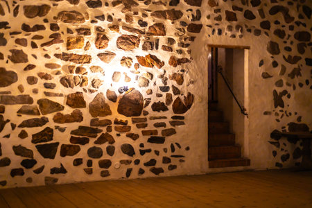 Old castle interior with antique furniture, stone walls, and warm light creating a medieval atmosphere full of history and mystery.の写真素材