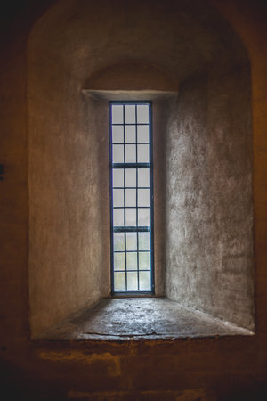 Old castle interior with antique furniture, stone walls, and warm light creating a medieval...